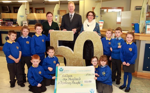 Rang a Trí pupils from Bunscoil an Iuir visited Newry Credit Union to present a cheque to Bóthar representative Aiobheann Fearon as part of their project “50 Years Ago. Also pictured is Brendan Jackson, Manager Newry Credit Union.