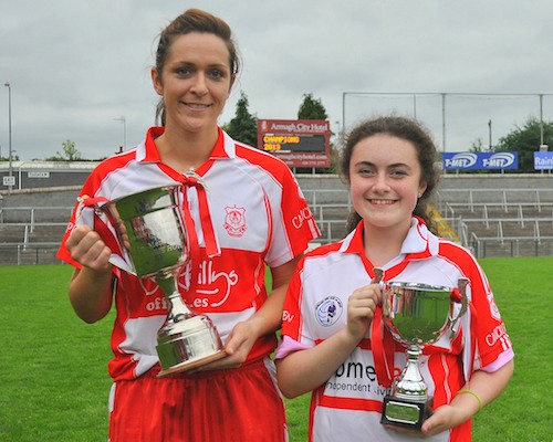 Carrickcruppen Ladies Senior Captain Caroline O'Hanlon and Under 14 Ladies Captain Orla Garvey show off the new silverware won by the South Armagh  club on Sunday. Photograph: Brendan Monaghan.