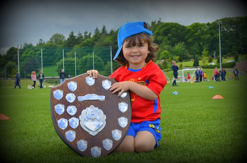 Two year old Joe Maguire gets his hands on the Carnbane U11 League Shield at St Colmans College on Sunday. Photograph: Brendan Monaghan