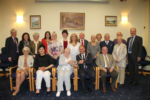 Chairperson of Newry, Mourne and Down District Council Mickey Ruane presents Florence McNulty with an inscribed crystal bowl at a Council reception in recognition of Florence's contribution to the Arts and Community life in the district. Florence pictured surrounded by friends