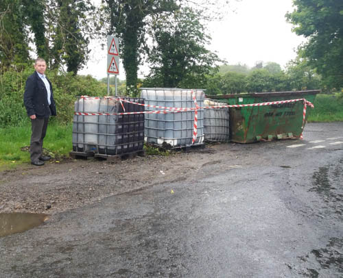 Cllr Mickey Larkin with the dumped containers