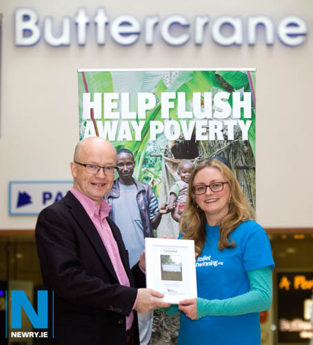 Buttercrane Manager Peter Murray with Susan Bennett, Toilet Twinning Fundraising Manager Northern Ireland checking out a photograph of the latrine block in Africa which is twinned with Buttercrane Shopping Centre toilets.