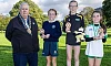 Newry, Mourne and Down District Council Chairperson, Councillor Glyn Hanna with the top three finishers in the Individual Girls race. Included are winner Emily Mc Greevy, Glasswater Primary School (centre), runner-up Sophia Murtagh, Ballyholland Primary School (left) and third placed Meabh Murtagh from Carrick Primary School, Burren.