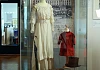 Silk and lace wedding dress belonged to Ella McGaffin purchased by Ella McGaffin from Foster & Co in Newry for her wedding in 1914. The dress, with ruffled and net sleeves and decorated with embroidery, is typical of the style of wedding dress worn in the second decade of the 20th century. It is displayed with R.J. Sloane’s umbrella, a boy’s velvet jacket and an early 20th century tall hat with its travelling box. Newry and Mourne Museum Collection