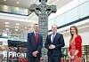 Communities Minister Gordon Lyons with Acting Director of PRONI David Huddleston and HERoNI’s Rhonda Robinson stand at the reconstructed Donaghmore high cross currently being exhibited at PRONI.