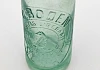 Moulded clear glass bottle, slightly wider at the shoulder than the base, long neck, would have had a metal bottlecap, label worked in glass 'C. Boden, Newry, registered trademark, Veritas Liberabit', 'wholesale bottlers' around base, 'British made, K. & Co. B., M586' on base. Newry & Mourne Museum Collection
