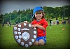 Two year old Joe Maguire gets his hands on the Carnbane U11 League Shield at St Colmans College on Sunday. Photograph: Brendan Monaghan