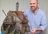 Garry McElherron with a model of his MourneQuest creaky old mansion perched on top of a tree that grows within a tree. Photograph: Columba O'Hare/ Newry.ie