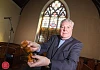Rev Norman Hutton surveys the damage done to the church window. Photograph: NewRayPics.com