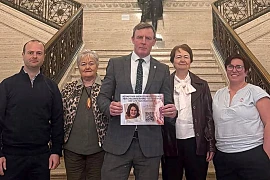 Justin McNulty presents the petition to the Stormont Assembly along with members of the Sherry and Garvey family.