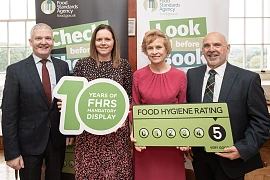 Newry, Mourne and Down District Council environmental health officers Sarah Davidson (second left) and Graham Farthing (right) at the celebration event at Parliament Buildings marking the 10th anniversary of the Food Hygiene Rating Scheme (FHRS), with Andy Cole (NI Food Standards Agency Director) and Food Standards Agency Chairperson Professor Susan Jebb.