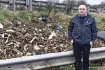 Cllr Aidan Mathers points out some of the litter at the side of the A1